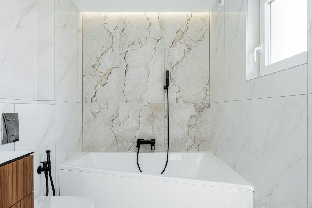 Modern bathroom with white marble and bathtub.