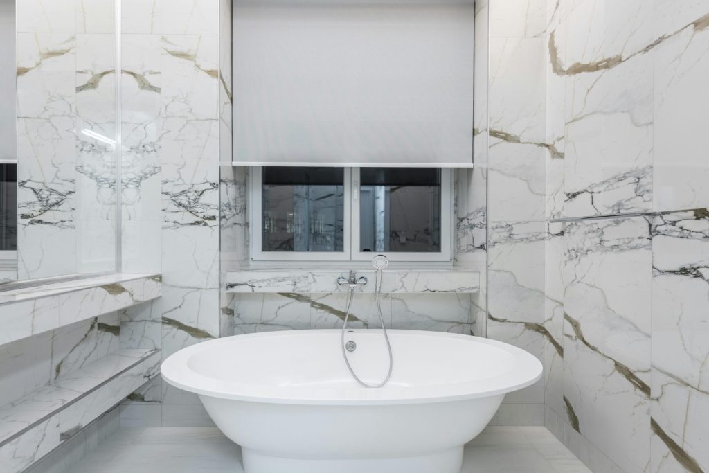Modern bathroom featuring a luxurious marble design and a sleek freestanding bathtub.