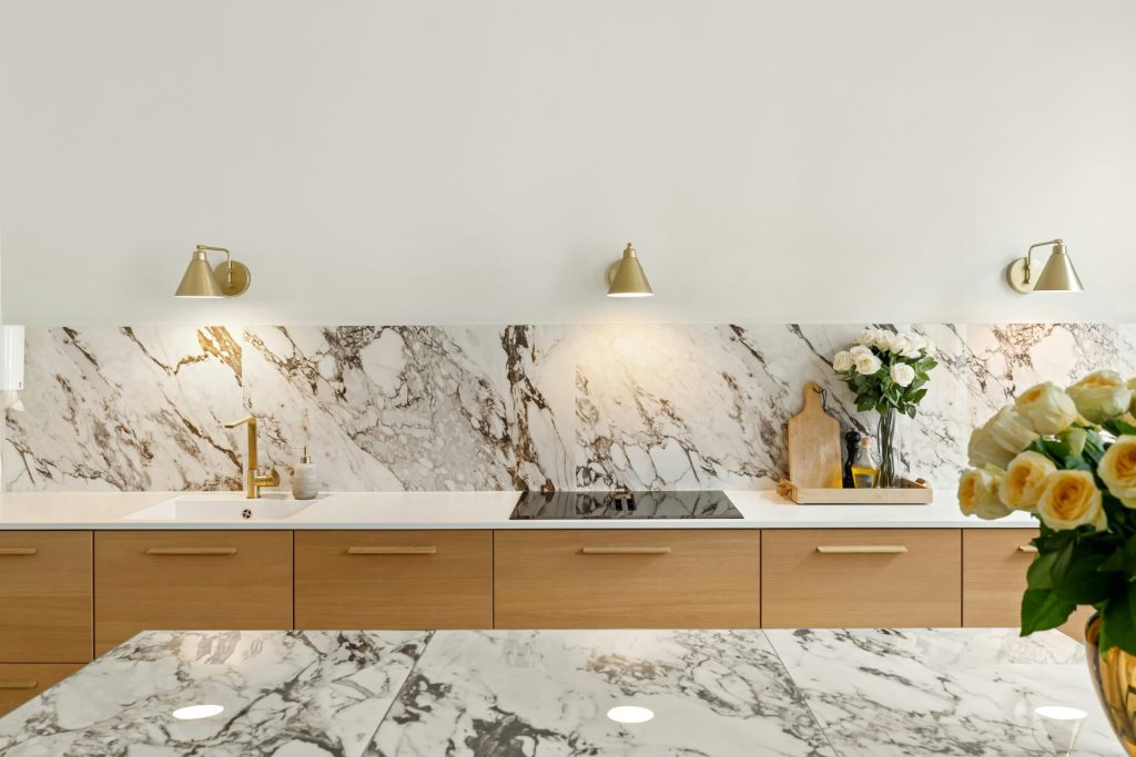 A kitchen with marble counter tops and gold accents