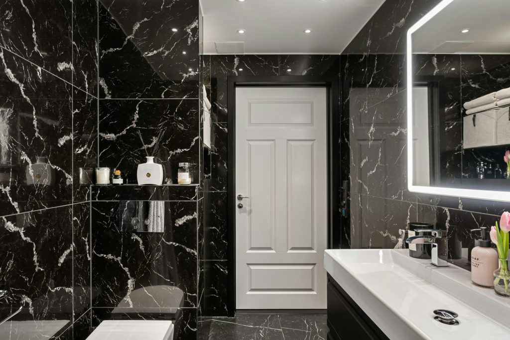 A black and white bathroom with a large mirror