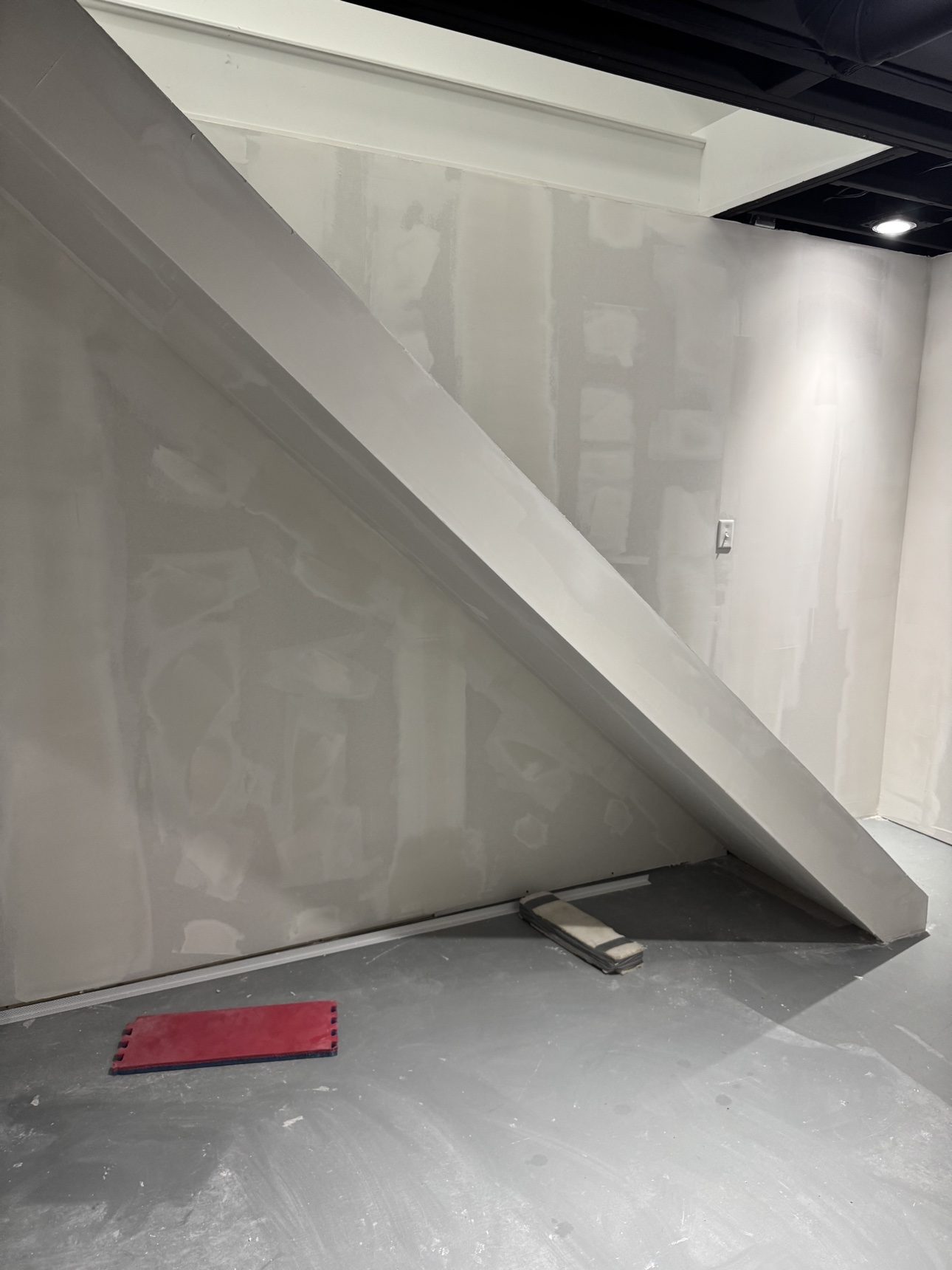 Basement wall panels being finished under a staircase during installation